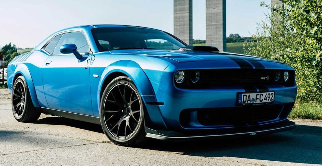 blue-dodge-challenger-parked-on-road-side A blue Dodge Challenger parked on the side of a road, showcasing its sleek design and vibrant color.