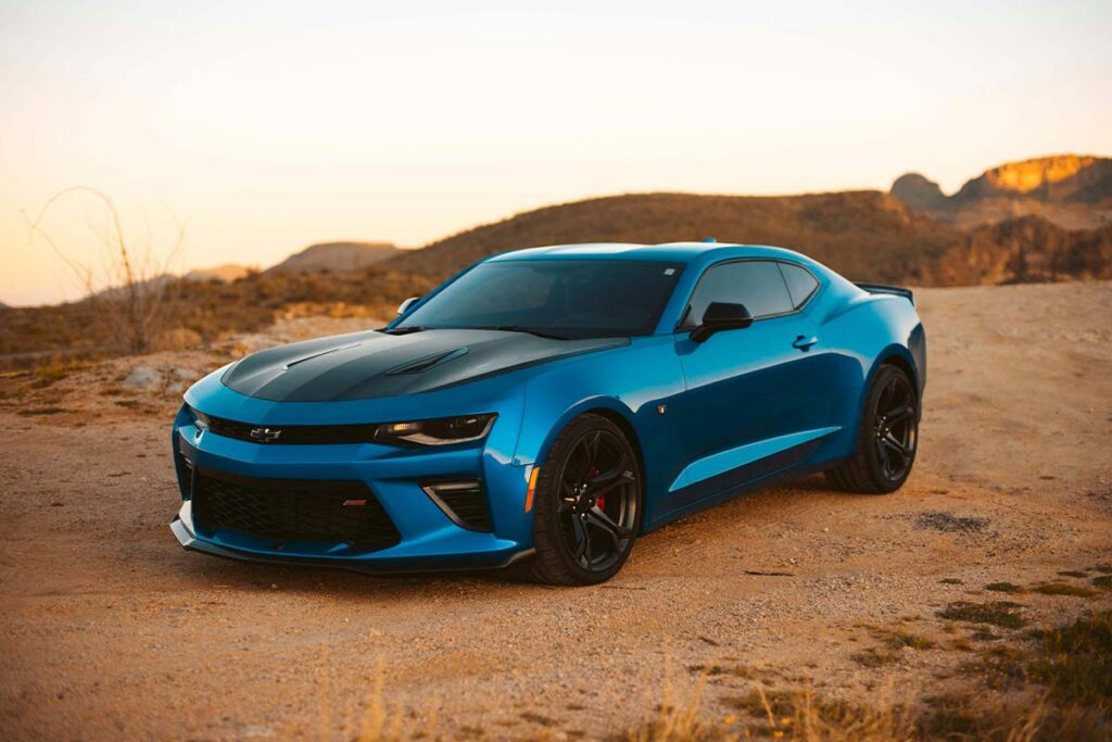 chevrolet-camaro-zl1-on-dirt-road 2020 Chevrolet Camaro ZL1 parked on a dirt road, showcasing its sleek design and powerful stance.