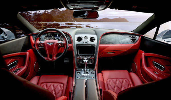 clean-car-interior-with-scenic-windshield-view A detailed/clean car's interior with a scenic landscape visible through the front windshield.