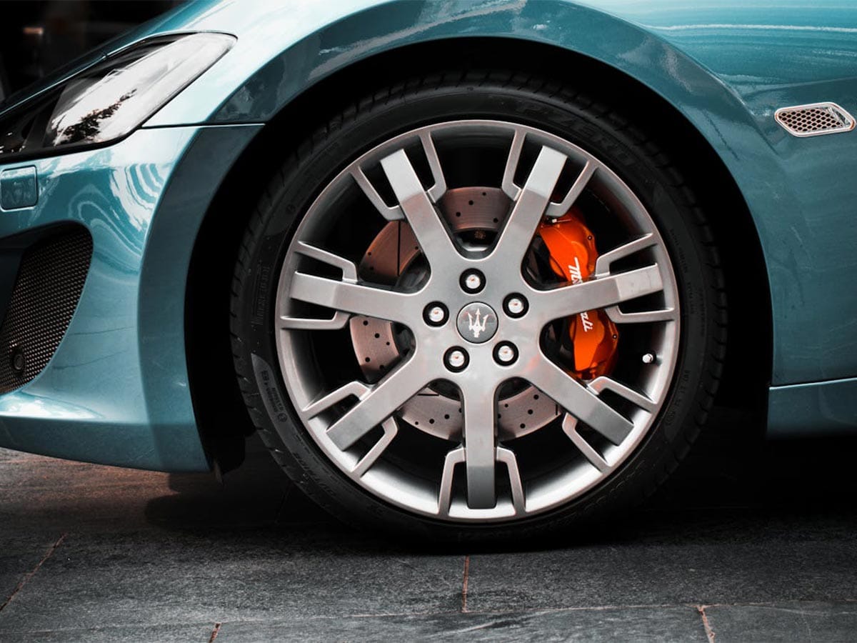 Close-up image of a blue car with eye-catching orange brake pads, illustrating the cryogenic-active brake cooling feature